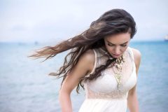 Beautiful young brunette woman outdoors portrait near the sea