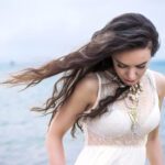 Beautiful young brunette woman outdoors portrait near the sea